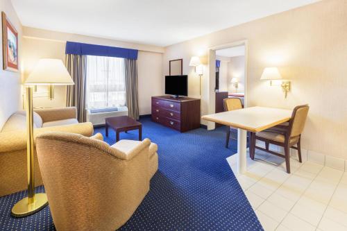 a hotel room with a table and chairs and a desk at Wyndham Garden Monterrey Norte in Monterrey