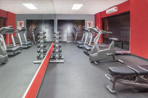 a gym with rows of tread machines and red walls at Wyndham Garden Monterrey Norte in Monterrey