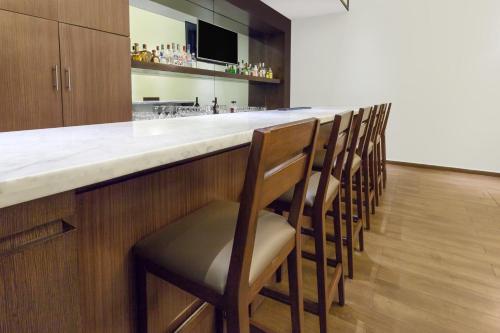 a bar with a row of stools in a kitchen at Wyndham Garden Monterrey Norte in Monterrey