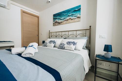 a bedroom with a large bed with white and blue pillows at Athena Garden House in Montesilvano
