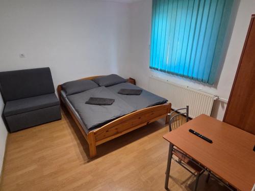 a small room with a bed and a chair at Penzión Poloniny in Ulič