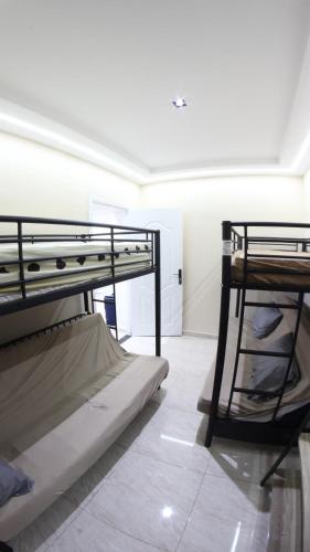 two bunk beds in a room with a tiled floor at Appartement Aokas Béjaïa in Aokas