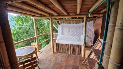 a bed in a bamboo house on a deck at Ecologic Mountain Cabin, amazing view in Santa Marta