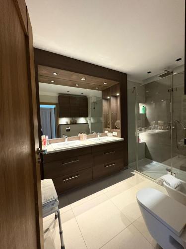 a bathroom with two sinks and a glass shower at Vijolie West Exclusive in Warsaw