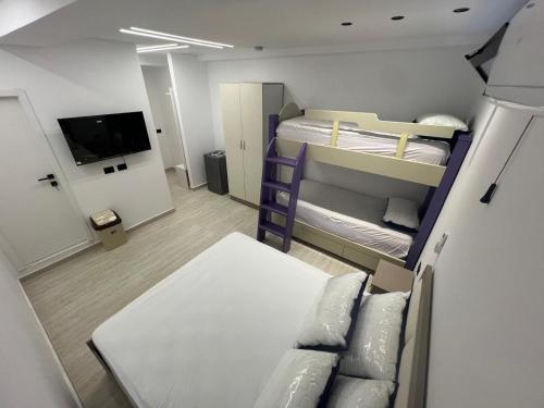 a small room with a bunk bed and a couch at Ferra Hostel in Durrës