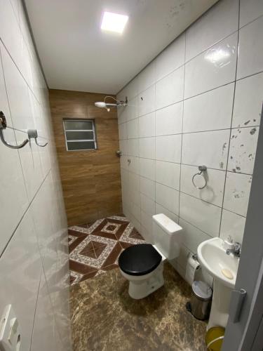 a bathroom with a toilet and a sink at Tucanos Club in São Paulo