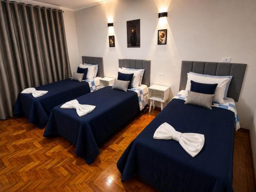 a room with three beds with bow ties on them at Casa p/ 7 | 3 quartos c/ ar e churrasqueira in Ourinhos