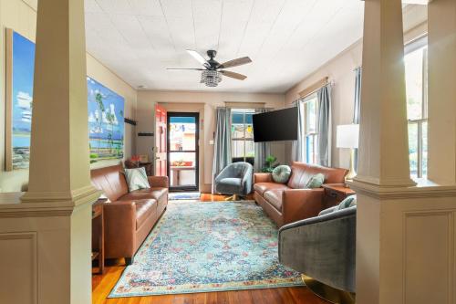 a living room with leather furniture and a ceiling fan at Casa Del Sol Historic St Aug Hideaway in St. Augustine