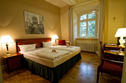 a bedroom with a large bed and a window at Klosterhotel Wöltingerode in Goslar