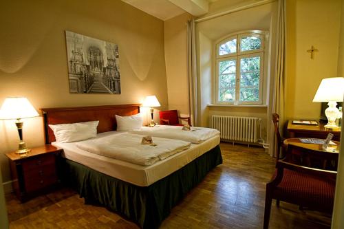 a hotel room with a large bed and a large window at Klosterhotel Wöltingerode in Goslar