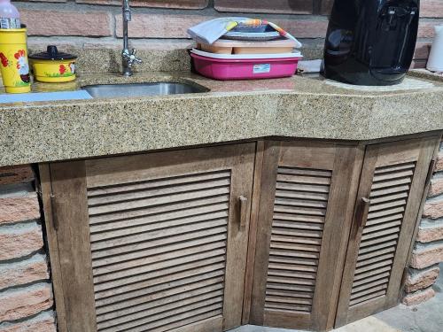 a kitchen counter with a sink and a container at Canto do Luar in Santa Cruz do Sul