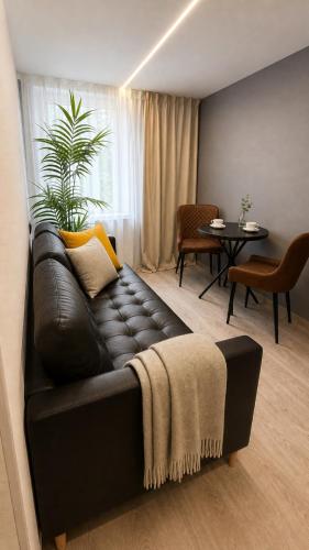 a black leather couch in a living room with a table at Rheinischer Hof Duisburg in Duisburg