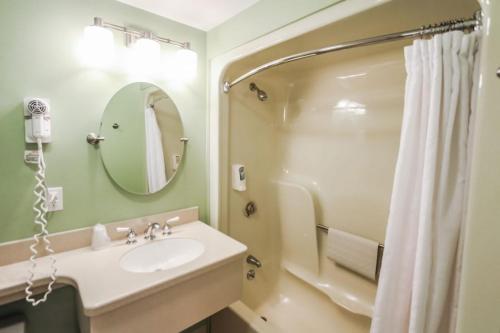 a bathroom with a sink and a shower with a mirror at Holly Tree Resort - Studio in Yarmouth