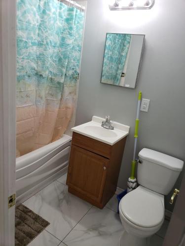 a bathroom with a toilet and a sink and a tub at Beautiful home in Brampton