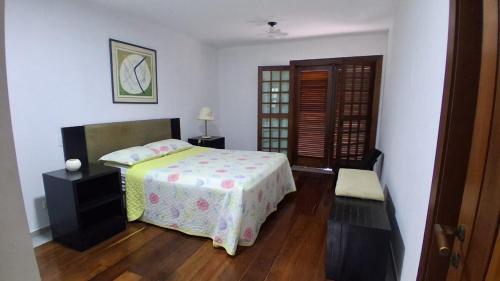 a bedroom with a bed and a wooden floor at Vista Joah in Joanópolis