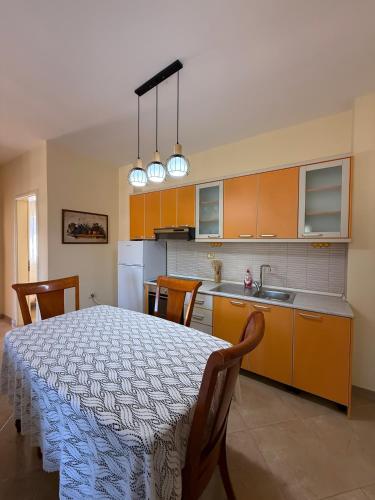 a kitchen with a table with chairs and a kitchen with a tableablish at Vlora Center Apartment - 5 Min to Lungomare in Vlorë