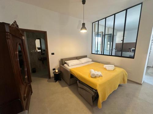 a bedroom with a bed with a yellow blanket at Amena Sea & City in Brindisi