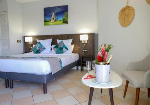 a bedroom with a bed and a chair and a table at Hôtel Saint-Georges in Saint-Claude