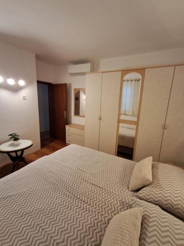 a bedroom with a large bed and a table at Apartments by the sea Barbat, Rab - 4975 in Rab