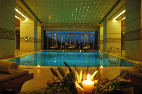 ein großer Pool in einem Hotel mit Kerzen in der Unterkunft Le Royal Amman in Amman