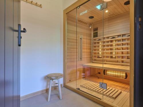 a glass door leading into a wine cellar with a stool at Guesthouse het Koetshuis in Bladel