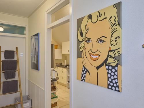 a painting of a woman on a wall in a kitchen at Wellnesshuisje Engelse Tuin in Oldenzaal