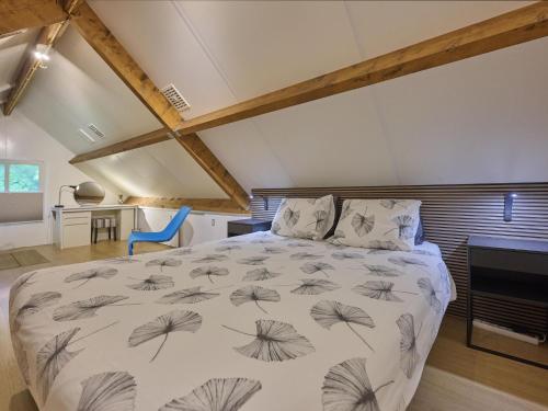 a bedroom with a large bed in a attic at Wellnesshuisje Engelse Tuin in Oldenzaal