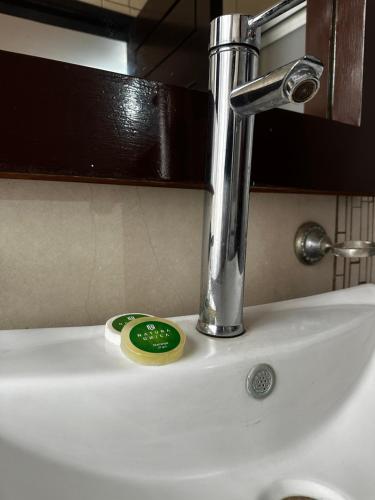 a sink with a faucet and a green button on it at Hotel kristal in La Barca