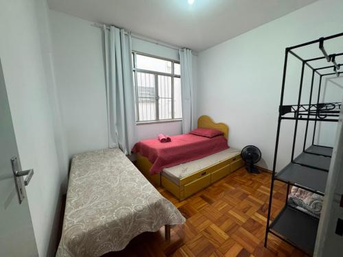 a small bedroom with a bed and a window at Comodidade in Caxambu