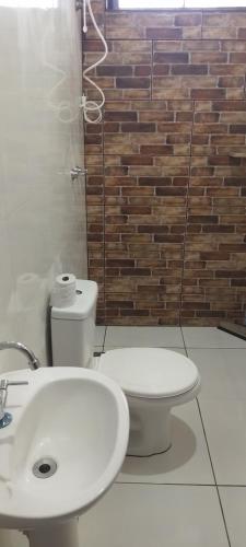 a bathroom with a toilet and a sink at Pousada santa Clara in Matão