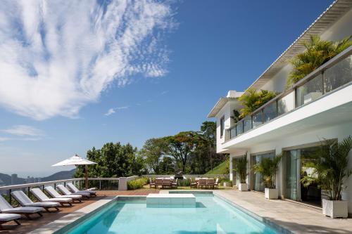 uma casa com piscina ao lado de um edifício em Vila Santa Teresa no Rio de Janeiro