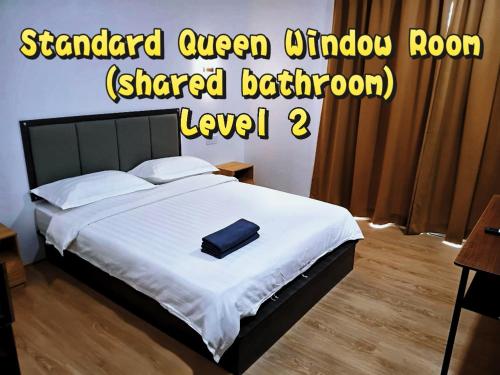 a bedroom with a bed with a black briefcase on it at Comfort Inn Salim in Sibu