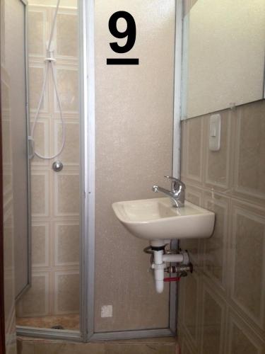 a bathroom with a sink and a shower with the number at Guesthouse Nelson L in Quito