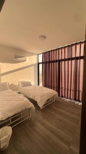 a bedroom with two beds and a large window at OASIS360 chalet in Sowayma