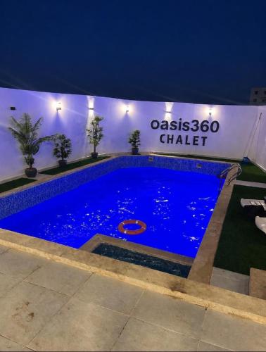 a large blue swimming pool in front of a building at OASIS360 chalet in Sowayma