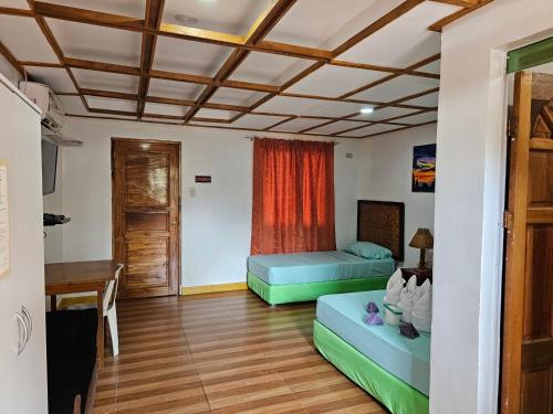 a room with two beds and a table at Paraiso ni Ronin in Tagudin