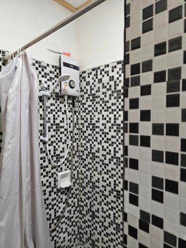 a bathroom with a shower with black and white tiles at Paraiso ni Ronin in Tagudin