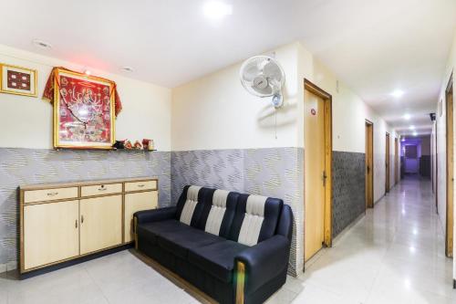 a living room with a couch and a fan at Hotel O Priyal in Chās