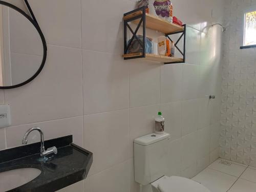 a bathroom with a toilet and a sink and a mirror at Xodó de Casa, Paracuru in Paracuru