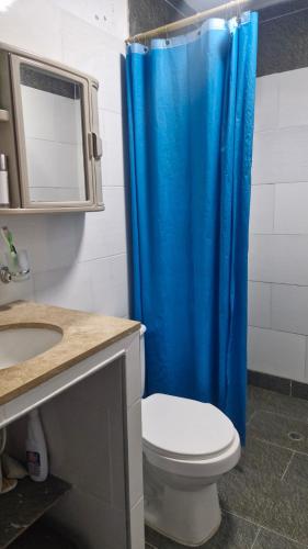 a bathroom with a blue shower curtain and a toilet at Villa Salguero in Gaira