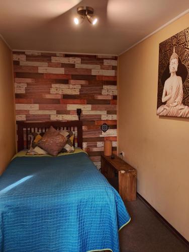 a bedroom with a bed and a brick wall at Hostal La Casa del Puente in Santiago