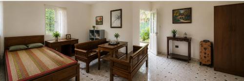 a bedroom with a bed and a desk and a table at PINE-APPALE Riverside Resort in Ấp Kế Mỹ