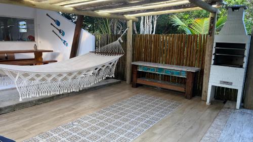 a porch with a hammock and a fireplace at Chalé Paraíso Corumbau - Chalés Uvas Azul in Corumbau