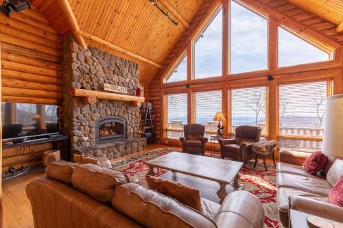 a living room with a stone fireplace in a log cabin at Good Day Sunshine in Lenoir