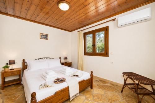 a bedroom with a bed and a wooden ceiling at Villa Old Vineyard in Kontogiannátika