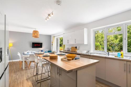 a kitchen with white cabinets and a large island at Downs Escape By My Getaways in Lancing
