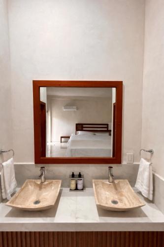 a bathroom with two sinks in front of a mirror at Hotel Casa del Rio in Santiago Tuxtla