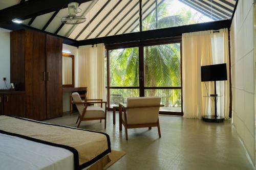 a bedroom with a bed and a table and chairs at Camp Thuduwa Udawalawe in Udawalawe