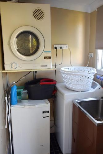 a kitchen with a washing machine and a sink at Mountain View Hat Head - Bring your own linen. in Hat Head