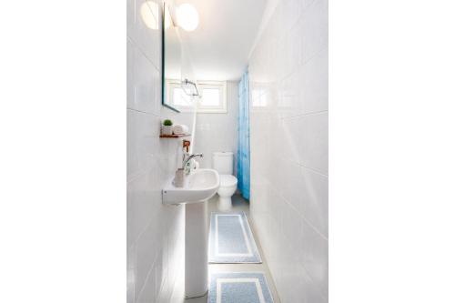 a white bathroom with a sink and a toilet at Panorama Villa in Pomos